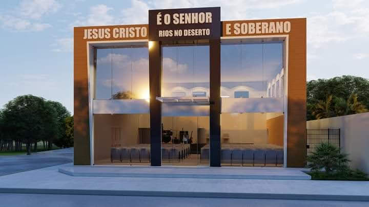 Vista frontal do templo moderno com letreiro e interior iluminado ao entardecer